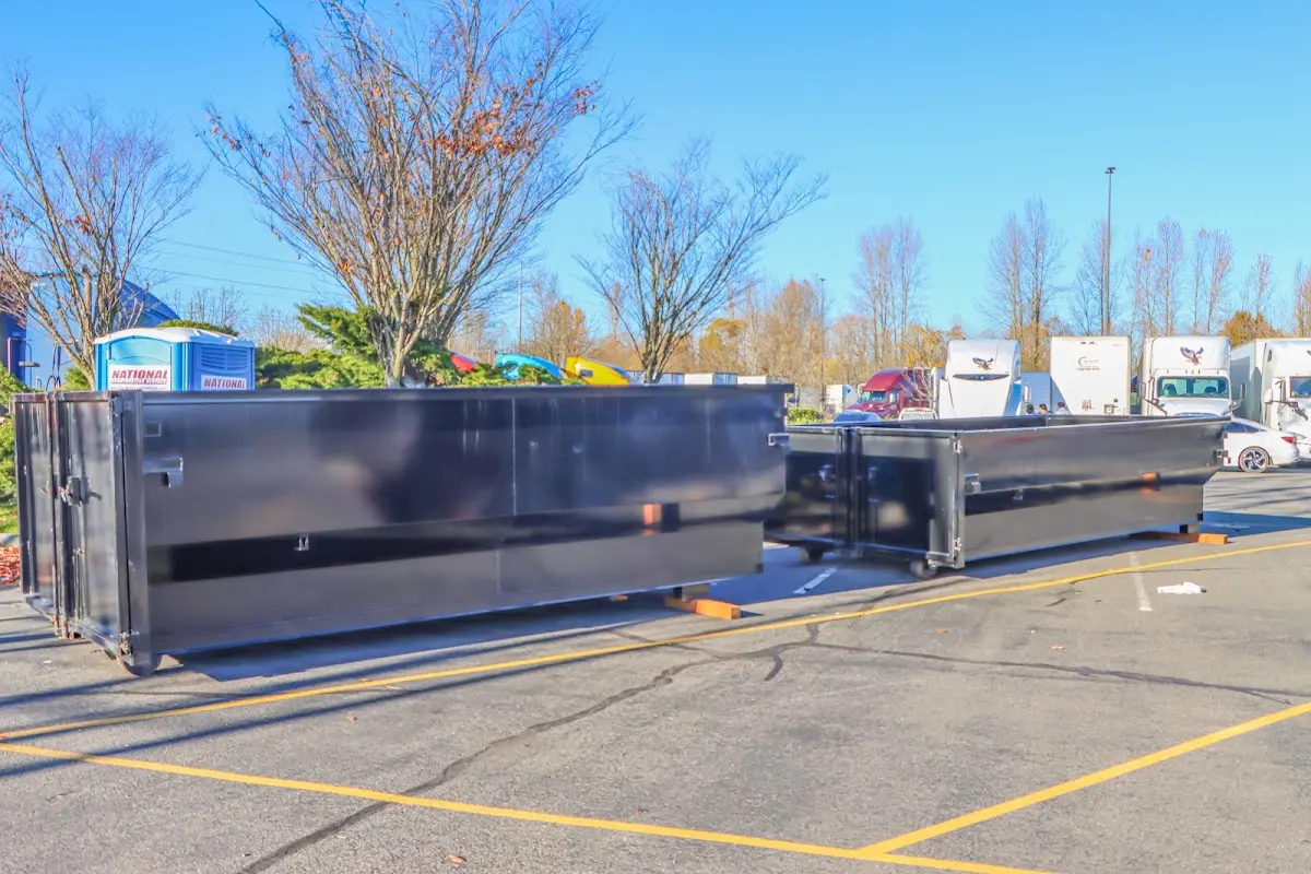 Professional dumpster rental service with roll-off container on residential driveway in Spotswood